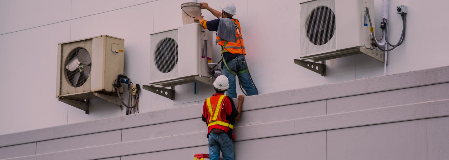 two workers fixing commercial heat pumps